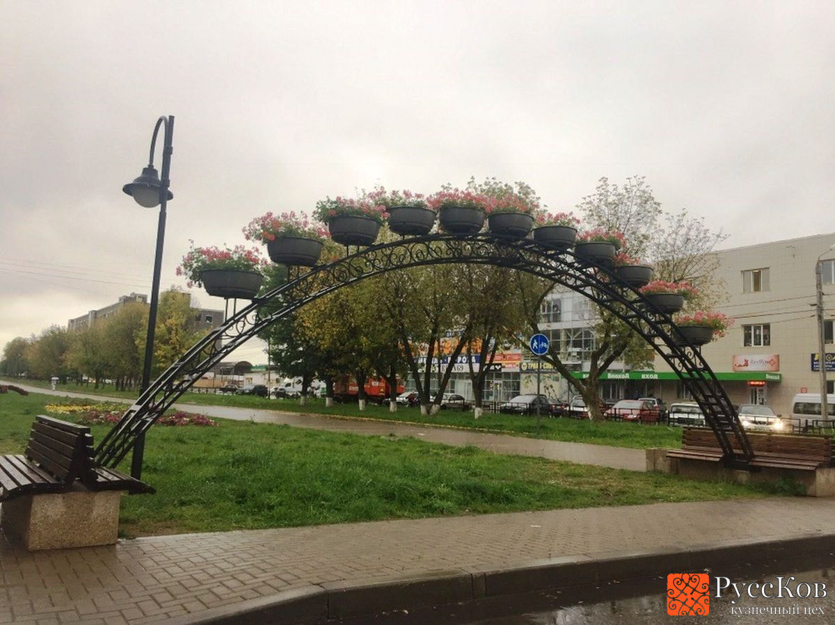 Кованая арка с цветочными клумбами на бульваре